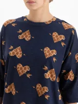 Remera de tejido flamé color azul marino con estampado de corazones con flechas en tonos marrones. Presenta cuello redondo y mangas tres cuartos con un corte holgado.