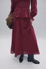 Falda midi de tiro alto con corte evasé y caída fluida. Presenta un diseño minimalista en color azul denim con cierre lateral oculto.
