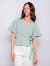 Blusa verde agua con textura acanalada, escote en V, mangas cortas amplias y lazo para atar en la cintura.