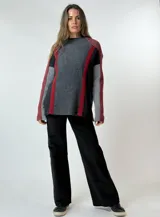 Sweater de punto grueso con cuello redondo, diseño de bloques de color en gris oscuro, gris claro, negro y rojo.