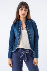 Chaqueta de estilo victoriano confeccionada en tejido denim azul, con cuello mao y cierre frontal de doble botonadura con botones plateados. Presenta bordes deshilachados y corte ajustado que realza la figura.