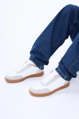 Championes urbanos de diseño minimalista, con cuerpo en color blanco, detalles en gamuza sintética color beige y suela de goma color caramelo.