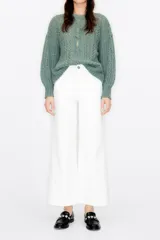 Pantalón culotte blanco de pana con tiro alto, largo tobillero, cierre de cremallera y botón metálico. Incluye bolsillos traseros y trabillas para cinturón.