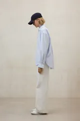 Camisa de algodón a rayas verticales finas celestes y blancas, con cuello clásico y corte holgado.