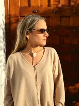 Buzo de tejido de punto color beige, de corte holgado y mangas largas.