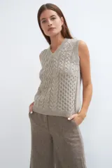 Chaleco de lana color crudo, tejido con escote en V y diseño con diferentes puntos combinados en el frente.