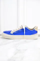 Zapatillas de cuero metalizado color azul con estrella dorada en el lateral, cordones blancos y detalles en color crema.