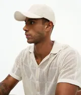 Gorra tipo dad hat de sarga con ala curva y ajuste trasero mediante hebilla metálica. Diseño minimalista y sin estampas.