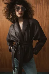 Chaqueta de Zara Woman Collection confeccionada en tejido efecto piel con textura granulada. Presenta cuello solapa, manga larga y cierre frontal con cinturón ajustable mediante lazada. Incluye forro interior.