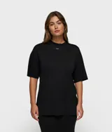 Remera negra de corte oversize con cuello redondo y etiqueta pequeña de la marca en el pecho.