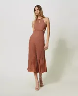 Vestido midi de punto color ladrillo con lurex, cuello halter con abertura en forma de lágrima y falda plisada con cortes en los laterales.
