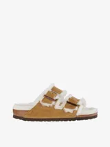 Sandalias Birkenstock Arizona con doble tira ajustable, forradas completamente en piel de oveja color tostado.