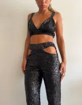 Top de bikini negro con lentejuelas, breteles anchos y espalda descubierta.