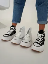 Championes tipo botita de caña alta con diseño bicolor, cuerpo en color negro y suela de plataforma gruesa en color blanco con base de goma.