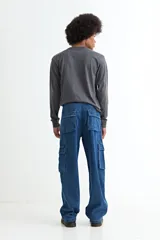 Pantalón tipo jean de corte baggy con diseño cargo, presenta bolsillos laterales amplios con solapa y costuras reforzadas. Confeccionado en denim de algodón con acabado lavado.