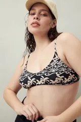 Top de bikini negro con estampado de palmeras y rayos de sol color crema, con escote redondeado y breteles finos.