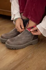 Bota corta de cuero color marrón oscuro con cierre frontal, plataforma y suela de goma.