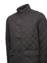 Chaqueta acolchada de estilo inglés con diseño de rombos, cierre frontal con botones y bolsillos laterales con solapa. Cuenta con relleno térmico sostenible.
