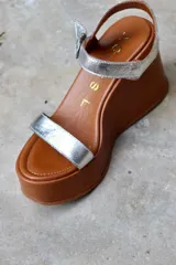 Sandalias de cuero color marrón chocolate con plataforma y taco corrido. Tira ancha sobre los dedos y tira al tobillo con hebilla dorada.