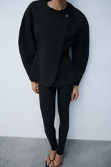 Leggings negros de tiro alto con bolsillos falsos de vivo en el delantero y cierre lateral con cremallera oculta. Presentan cremalleras ocultas en los bajos.