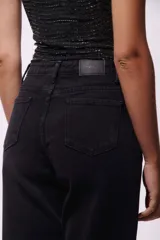 Pantalón de jean negro de corte recto, con cintura alta y ruedo doblado.