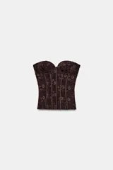 Corsé de encaje negro con escote corazón, hombros descubiertos y varillas interiores para estructura. Cuenta con cierre lateral mediante cremallera oculta.