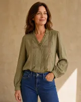 Camisa verde militar de manga larga, con escote en V con volados y detalles de encaje y alforzas en el frente.