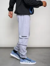 Pantalón cargo gris melange de algodón, poliéster y elastano, con bolsillos laterales tipo parche en las piernas y puños ajustados en los tobillos.