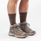 Calzado de trekking Salomon modelo X Ultra 360 Leather Mid Gore-Tex, de corte alto, color marrón y tostado con detalles en verde. Confeccionado con cuero resistente, malla y membrana impermeable Gore-Tex.