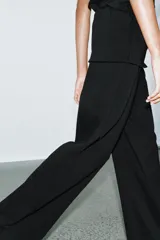 Pantalón de algodón compacto color beige, de tiro alto con cintura elástica y detalle de fajín y cordones.