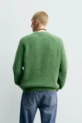 Sweater de punto perlado botonato en color marrón, corte regular fit, con cuello redondo y manga larga.
