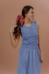 Vestido midi sin mangas de color azul con estampado a cuadros vichy. Presenta la parte superior completamente elastizada y ajustada con efecto fruncido, y falda amplia y suelta.