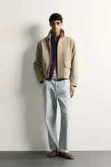 Cazadora relaxed fit de piel y ante color beige, con cuello solapa, manga larga con puño, bolsillos delanteros con solapa y cierre frontal oculto con cremallera y botones a presión.