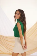 Chaleco de punto verde con lurex, cuello alto y sin mangas.