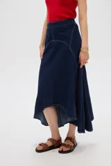 Falda larga de denim azul oscuro con costuras en contraste y diseño asimétrico de corte evasé.