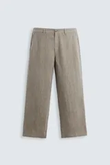 Pantalón de corte straight relaxed fit confeccionado en tejido de lino con efecto lavado. Presenta cierre frontal con cremallera y botón, bolsillos laterales y bolsillos traseros de vivo.
