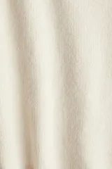 Buzo de punto suave con corte holgado, cuello redondo y mangas raglán. Presenta terminaciones acanaladas en el cuello, los puños y el bajo.