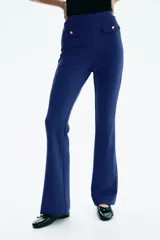 Pantalón acampanado de punto roma, color azul, con elástico oculto en la cintura y solapas de bolsillo decorativas con botón dorado en el frente.