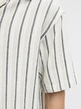 Camisa de manga corta con fit relajado y cuello resort. Cierre con botones al frente. Estilo liviano ideal para el verano.