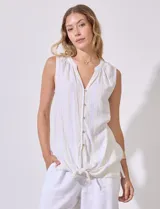 Blusa sin mangas de lino y rayón a rayas verticales amarillas y celestes, con cuello a la base y escote en V, abertura central con botones y terminación anudada.