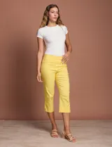 Pantalón capri blanco de gabardina elastizada. Pretina ancha elastizada, delantera con bolsillos simulados y trasera con bolsillos aplicados.