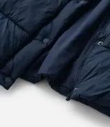 Campera puffer acolchada color azul marino, con capucha, cierre frontal con broches a presión, bolsillos laterales y cordón regulador en la cintura para ajuste entallado.