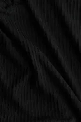 Top negro de manga larga en tejido de punto acanalado fino. Presenta un escote en V profundo con una pequeña abertura frontal cerrada con dos corchetes ocultos.