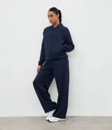 Campera deportiva de cuello alto con cierre frontal, mangas largas con puños elásticos y diseño de corte raglán. Presenta un estilo minimalista y funcional con cintura ajustable.