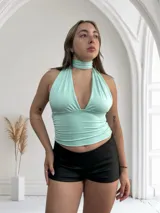 Top amarillo pálido con cuello halter y escote profundo. Se puede usar de múltiples formas.