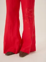Pantalón de lino color azul metalizado, de corte sastrero, tiro medio y pierna recta amplia.