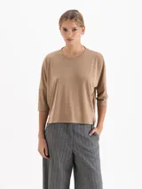 Remera de silueta relajada confeccionada en tela de punto suave. Presenta escote redondo, mangas 3/4, recorte estratégico en la espalda y tajos laterales que aportan movimiento y una caída fluida.