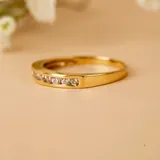 Anillo tipo alianza de oro 18k con engaste de circonias en la mitad superior.