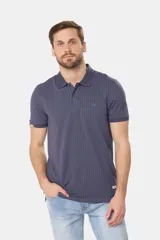 Remera polo de piqué en color azul con estampado de mini print geométrico en toda la prenda. Presenta cuello clásico, cierre frontal con botones personalizados y logo bordado en el pecho.