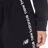 Pantalón de jogging negro de frisa, con puños ajustados y logo de New Balance estampado en blanco a lo largo de la pierna.